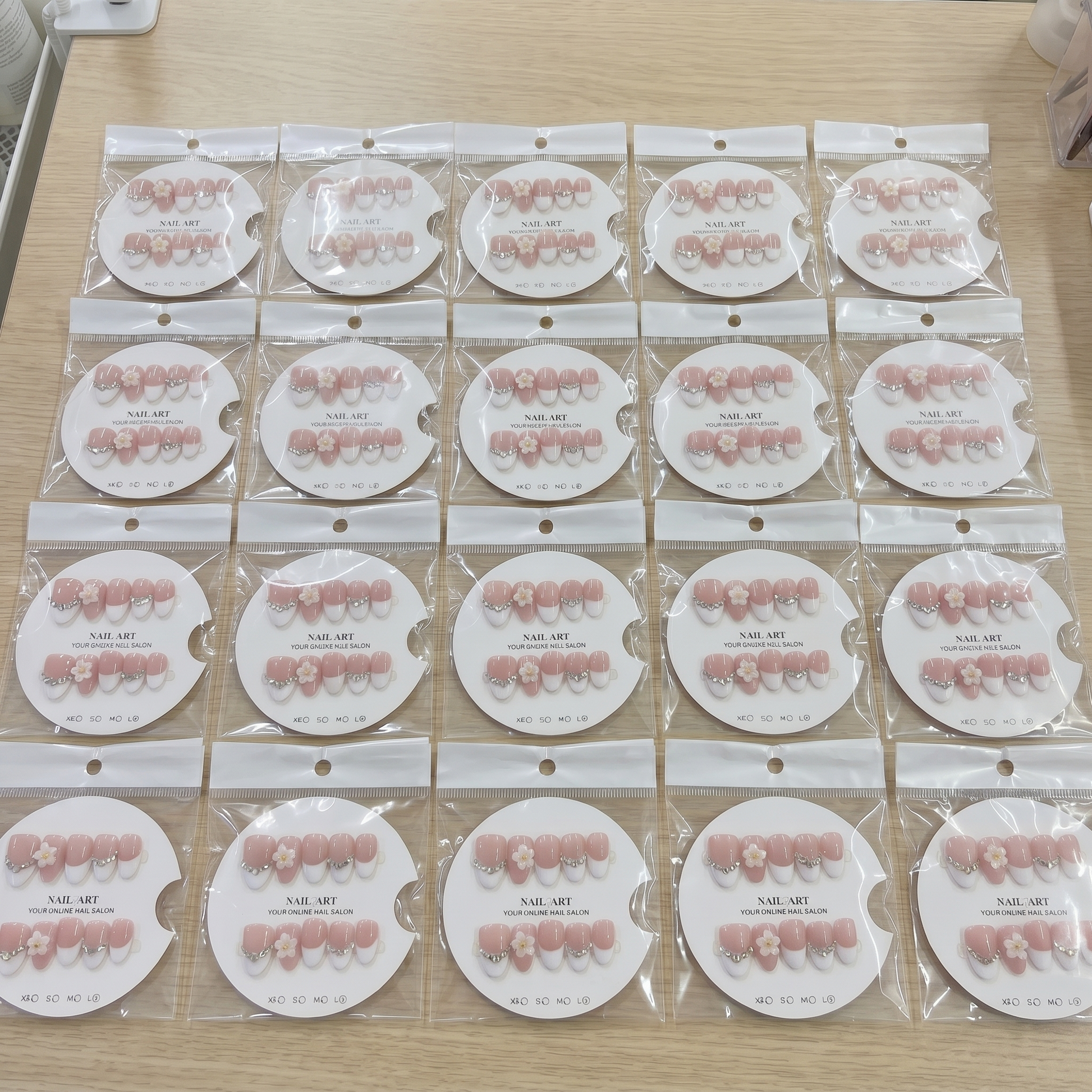 A complete set of almond-shaped white French tip press on nails with 3D daisies and rhinestones, organized by size on display cards.