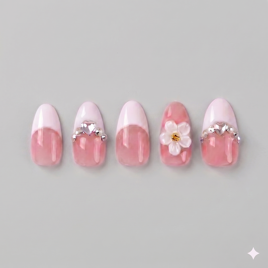 Elegant almond-shaped white French tip press on nails on a nude pink base, featuring a large 3D white daisy and sparkling rhinestone accents.