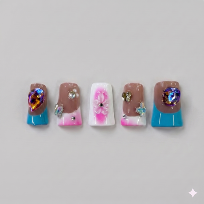 Mix and match blue and pink square press on nails featuring statement 3D blue ribbon bows, delicate floral patterns, and sparkling rhinestones.