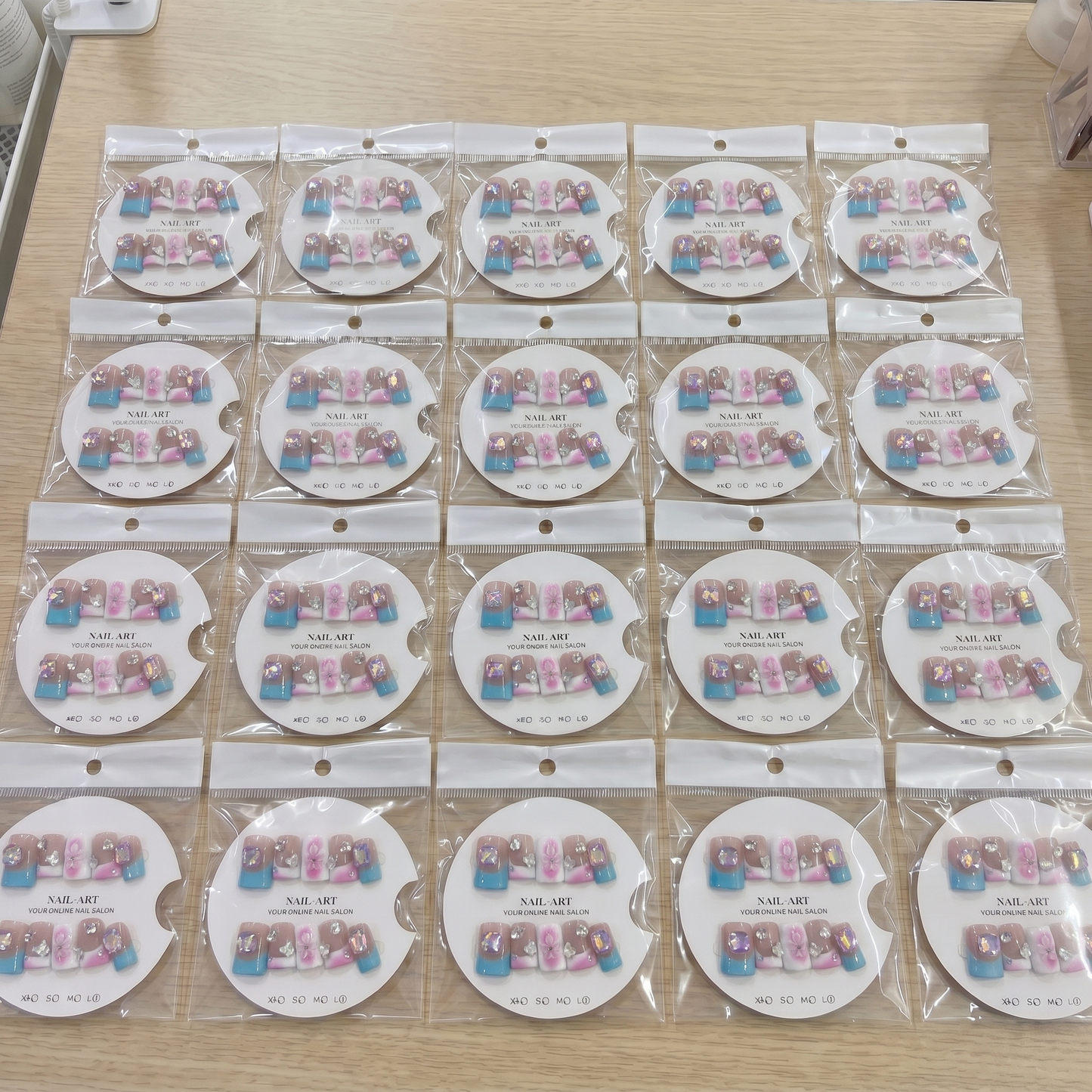 Full set of blue and pink mix and match 3D bow square press on nails displayed on size cards.