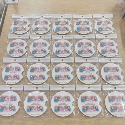 Full set of blue and pink mix and match 3D bow square press on nails displayed on size cards.