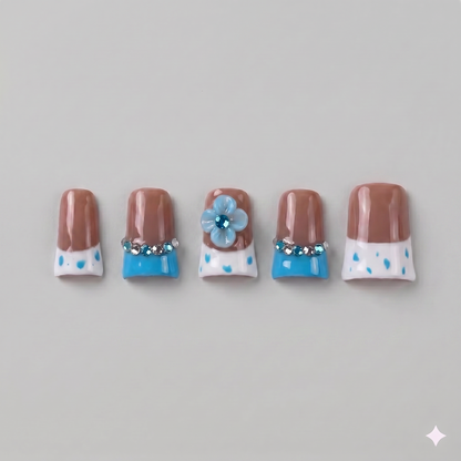 Brown and blue polka dot square press on nails featuring a 3D blue blooming flower, a ribbon bow, and vibrant French tips.