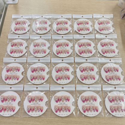 Full set of hot pink floral French tip almond press on nails displayed on size cards.