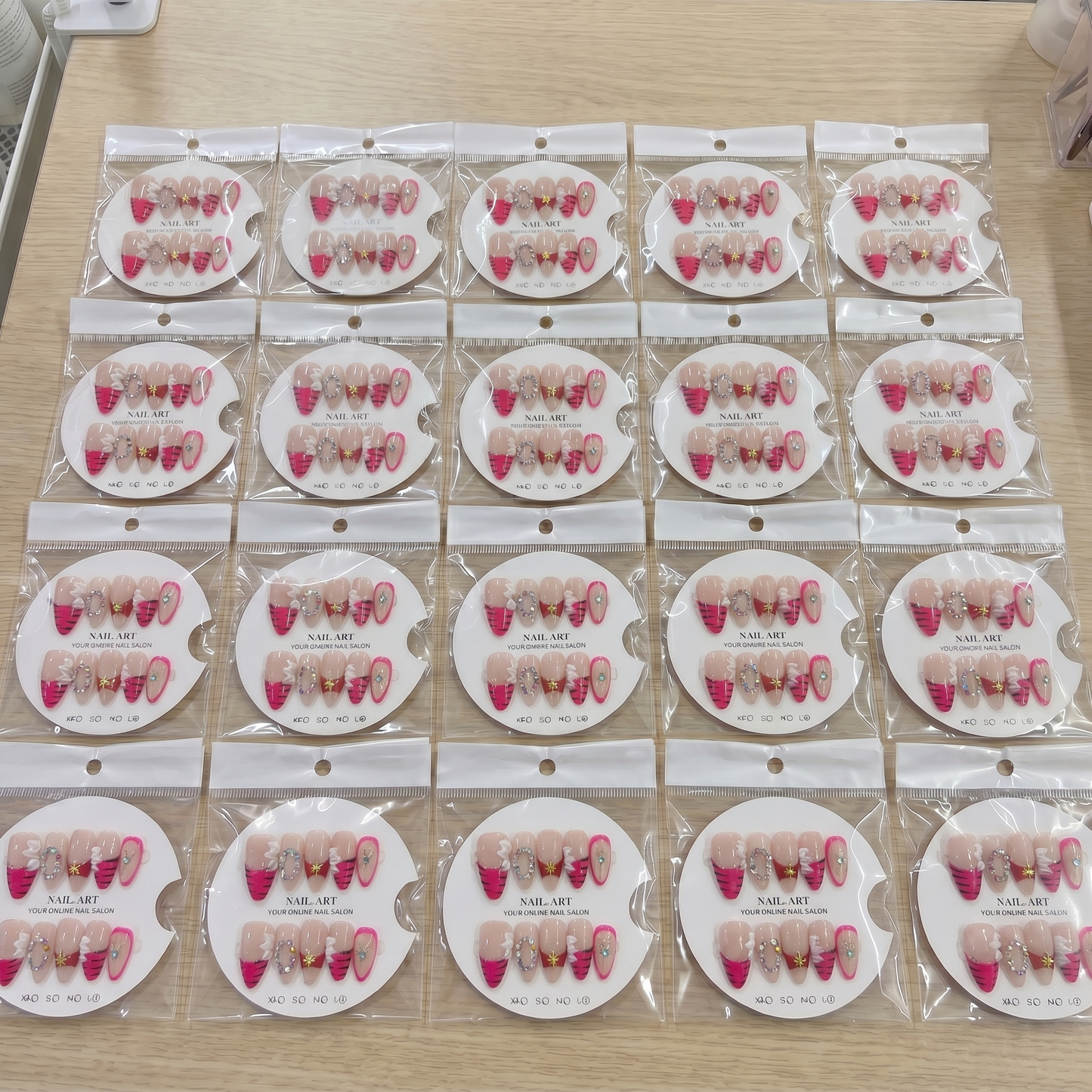 Full set of hot pink mix and match 3D gem almond press on nails displayed on size cards.
