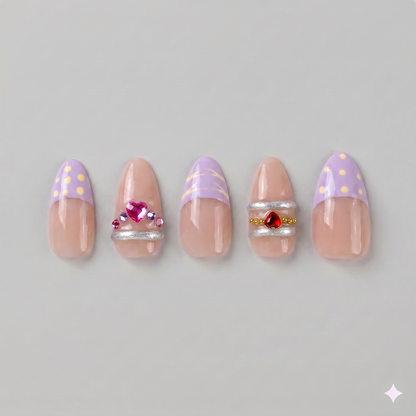 Lavender gold swirl almond press on nails featuring soft French tips, elegant gold chrome swirls, and sparkling pink and red rhinestones.
