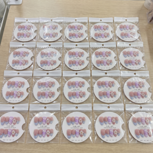 Full set of lavender polka dot 3D floral almond press on nails displayed on size cards.