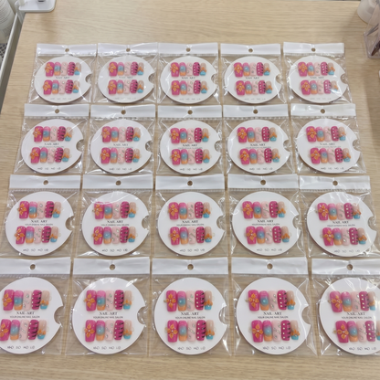 Full set of orange and pink 3D floral square press on nails displayed on size cards.