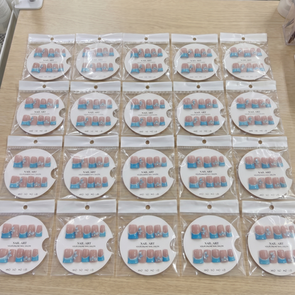 Full set of sky blue French tip 3D bow square press on nails displayed on size cards.